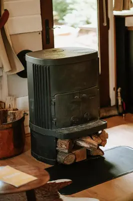 a stove sitting on top of a pile of wood at Le chalet Sud in Verviers