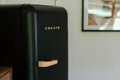 a black refrigerator with a magnetic create sign on it at Le chalet Sud in Verviers