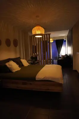 a bedroom with a large bed with a chandelier at SpaNChill in Herstal