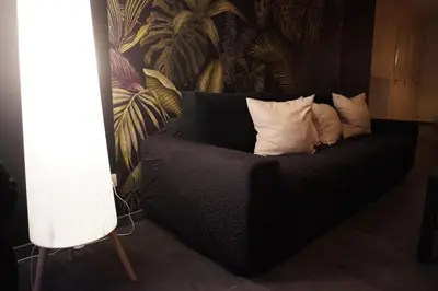 a black couch with pillows on it in a room at SpaNChill in Herstal