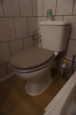 a bathroom with a toilet with a roll of toilet paper on top at ChambreNchill in Seraing
