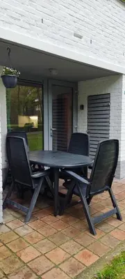 a picnic table and two chairs on a patio at Vakantiebungalow BERK 1 in Houthalen-Helchteren