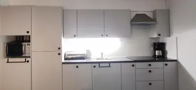 a kitchen with white cabinets and a sink at Vakantiebungalow BERK 1 in Houthalen-Helchteren