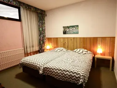 a bedroom with a bed and two lamps and a window at Halinsart in Trooz