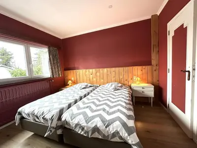 a bedroom with a bed and a red wall at Halinsart in Trooz