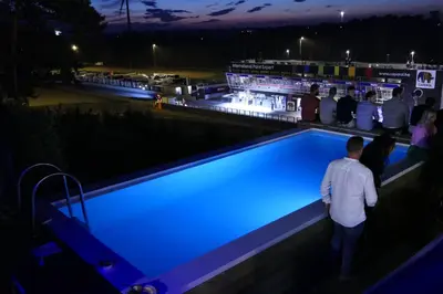 a group of people standing around a pool at night at GT Lounge Zolder in Heusden - Zolder