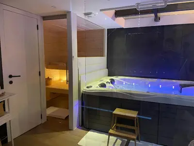 a bathroom with a tub with a stool in it at Ô voda in Waremme
