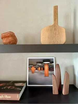 a shelf with a picture and shoes on a table at Zalig HASPENGOUW in Sint-Truiden