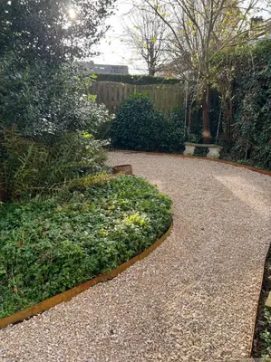 a walkway in a garden with plants and a fence at Zalig HASPENGOUW in Sint-Truiden