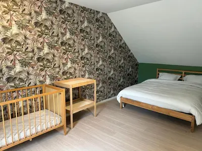 a bedroom with a bed and a wallpaper with palm trees at Vakantiehuis Twenty Six in Hasselt