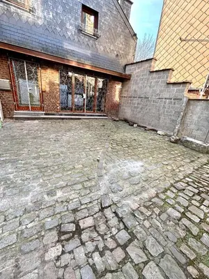 an empty brick parking lot in front of a building at Aux portes du marché in Verviers