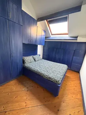 a room with a bed in a room with blue cabinets at Aux portes du marché in Verviers