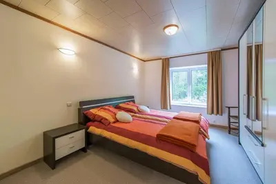 a bedroom with a bed and a large window at Tweekamer Apartement in Dilsen-Stokkem