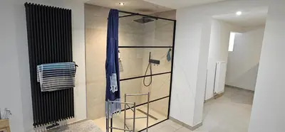 a shower with a glass door in a bathroom at Comme chez Soi in Liège