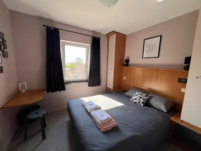 a small bedroom with a bed and a window at Klappoel - by Cafe Rene Borgloon in Borgloon