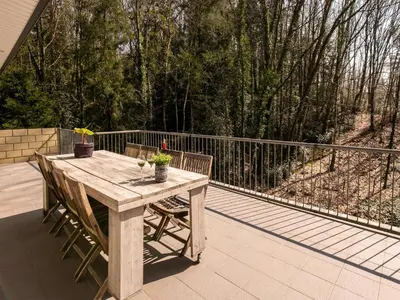 a wooden table and two chairs on a patio at Holiday Home in Lanklaar near Forest Trails in Lanklaar