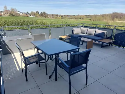 a patio with tables and chairs and a couch at L'Appart - New Appartement - Free Parking - Self Check-in - Terrasse in Eynatten