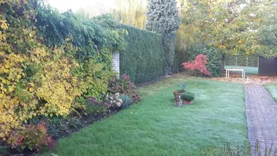 a garden with a hedge and a table in the yard at Take a break in Voeren