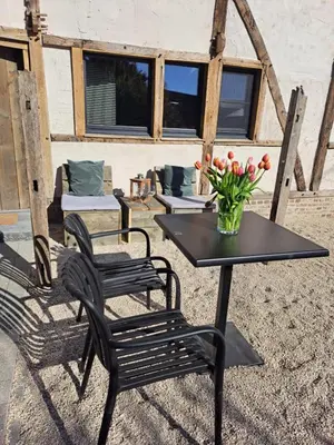 a table and two chairs and a vase of flowers at Hoeve BôThé - B&B in Alken