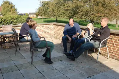 a group of people sitting in chairs on a patio at Alfonsinehoeve - we gaan zelf niet op vakantie, de vakantie komt naar ons in Heers