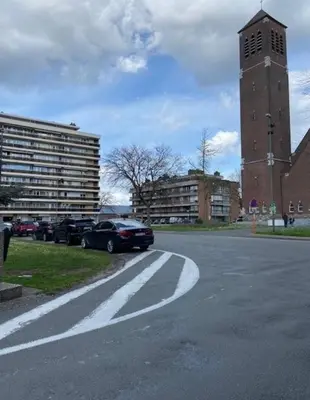 a parking lot with cars parked in front of a building at Hasselita in Hasselt