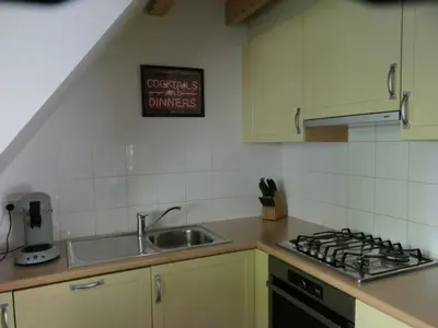 a kitchen with a sink and a stove top oven at De Onthaasting in Lanaken