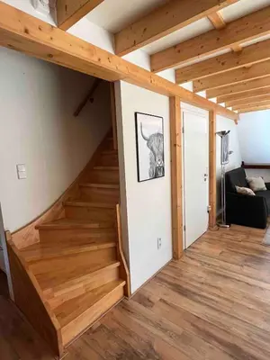 a staircase in a house with wooden ceilings at De Onthaasting in Lanaken