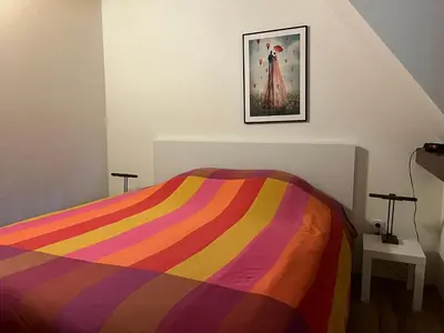 a bed with a colorful striped comforter in a room at De Onthaasting in Lanaken
