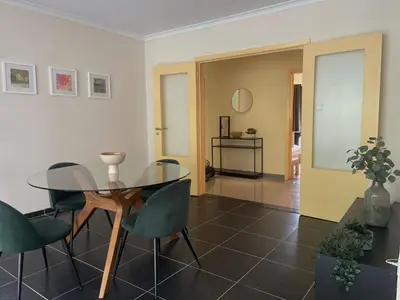 a dining room with a glass table and green chairs at Comfortable stay in Tongeren in Tongeren