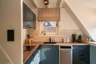 a kitchen with blue cabinets and a window at Boshuisje Rekem - Azure in Lanaken