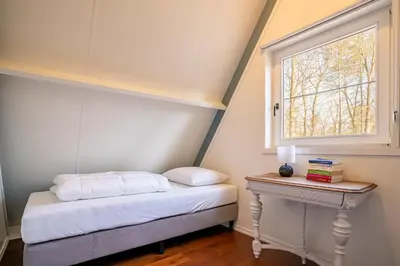 a small bedroom with a bed and a window at Boshuisje Rekem - Azure in Lanaken