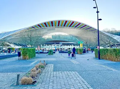 a large building with people walking in front of it at Le cocon de la gare - centre in Liège