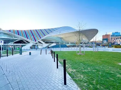 a large building with a roof in a park at Le cocon de la gare - centre in Liège