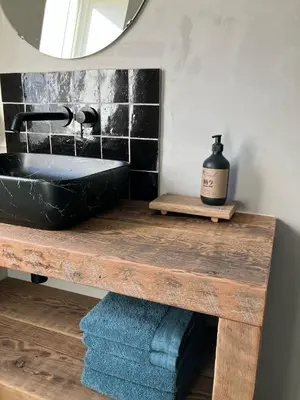 a bathroom with a black sink and a mirror at Huisje Emma in Tongeren