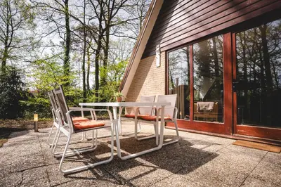 two chairs and a table on a patio at Boshuisje Rekem - Ember in Lanaken