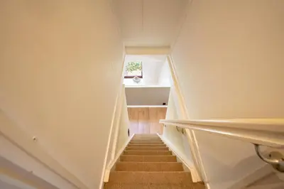 a staircase in a house with a small window at Boshuisje Rekem - Ember in Lanaken