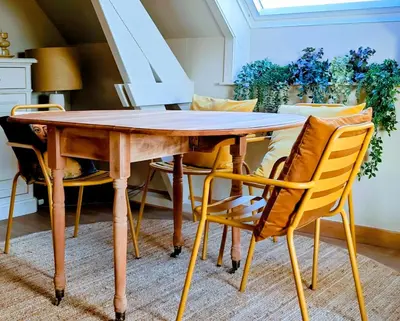 a dining room table with yellow chairs around it at 't Herenhoes in Pelt
