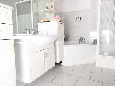 a white bathroom with a sink and a tub at La Cachette d 'Amercoeur in Liège