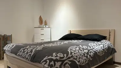 a bedroom with a bed with a black and white blanket at Le Rez d'Amercoeur in Liège