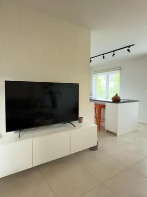 a living room with a large flat screen tv at Genk Central Apartment in Genk
