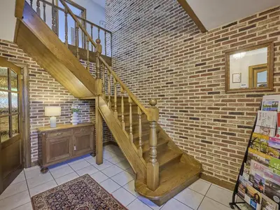 a staircase in a brick walled room with a stair case at Hesbein in Tongeren
