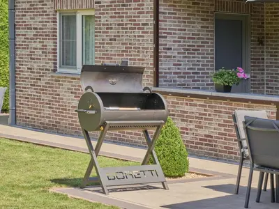 a grill on a stand in front of a building at Hesbein in Tongeren