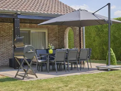 a table and chairs under an umbrella on a patio at Hesbein in Tongeren