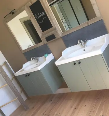 a bathroom with two sinks and a mirror at Vakantiewoning Huys op de Locht in Scherpenberg