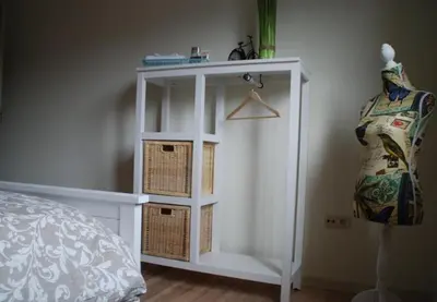 a bedroom with a white book shelf with baskets on it at Vakantiewoning Huys op de Locht in Scherpenberg
