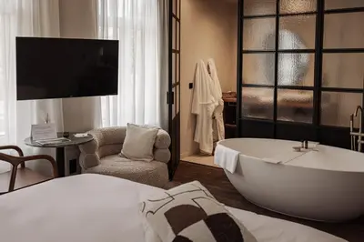 a hotel room with a bath tub and a bedroom at Guesthouse Just Be Mine in Beringen