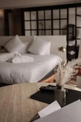 a bedroom with a bed and a table with a remote control at Guesthouse Just Be Mine in Beringen