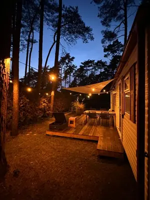 a porch of a house with a wooden deck at night at Chalet Tibi in Bocholt