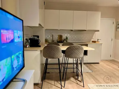 a kitchen with a table and two bar stools at Le coeur Liégeois - Hypercentre quartier piéton in Liège
