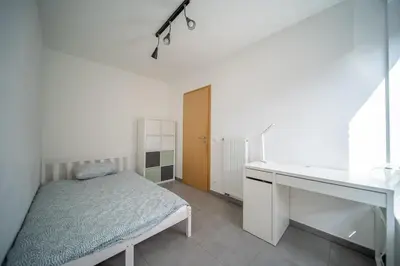 a bedroom with a bed and a desk and a sink at Liège 3 Bedroom Apartment, Quiet and Central in Liège